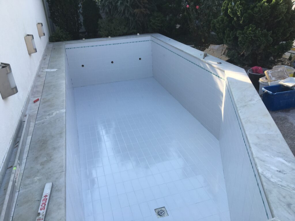 Schwimmbecken mit neu verlegten Bodenfliesen und Wandfliesen