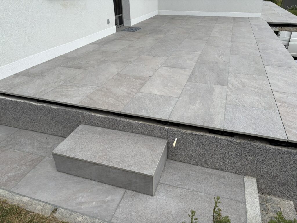 Terrassenplatten auf Schienensystem mit betonierter Zugangsstufe