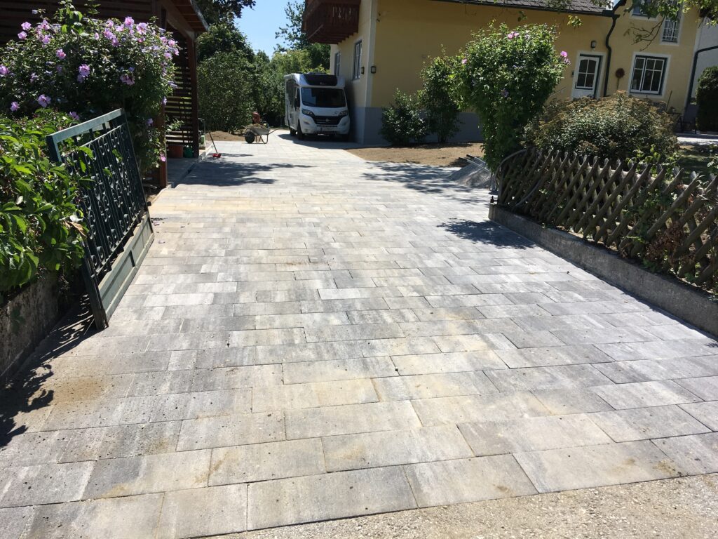 Gepflasterte Hauseinfahrt mit rechteckigen Pflastersteinen