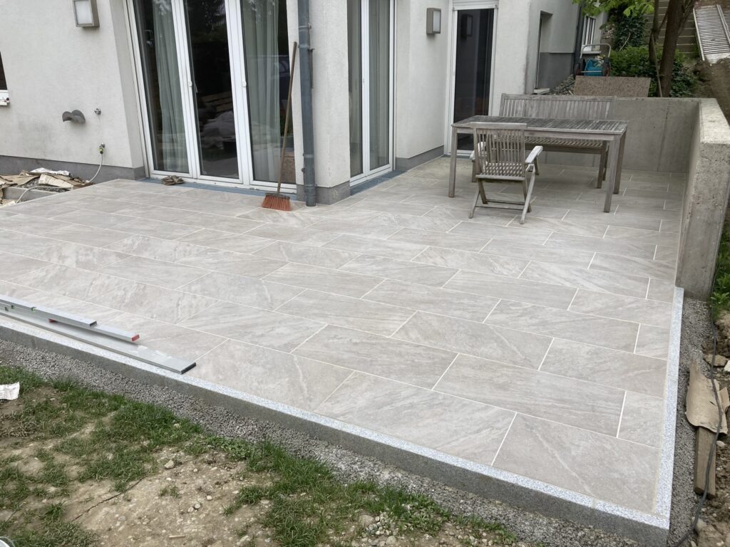 Terrasse mit großformatigen Platten und umlaufender Randeinfassung